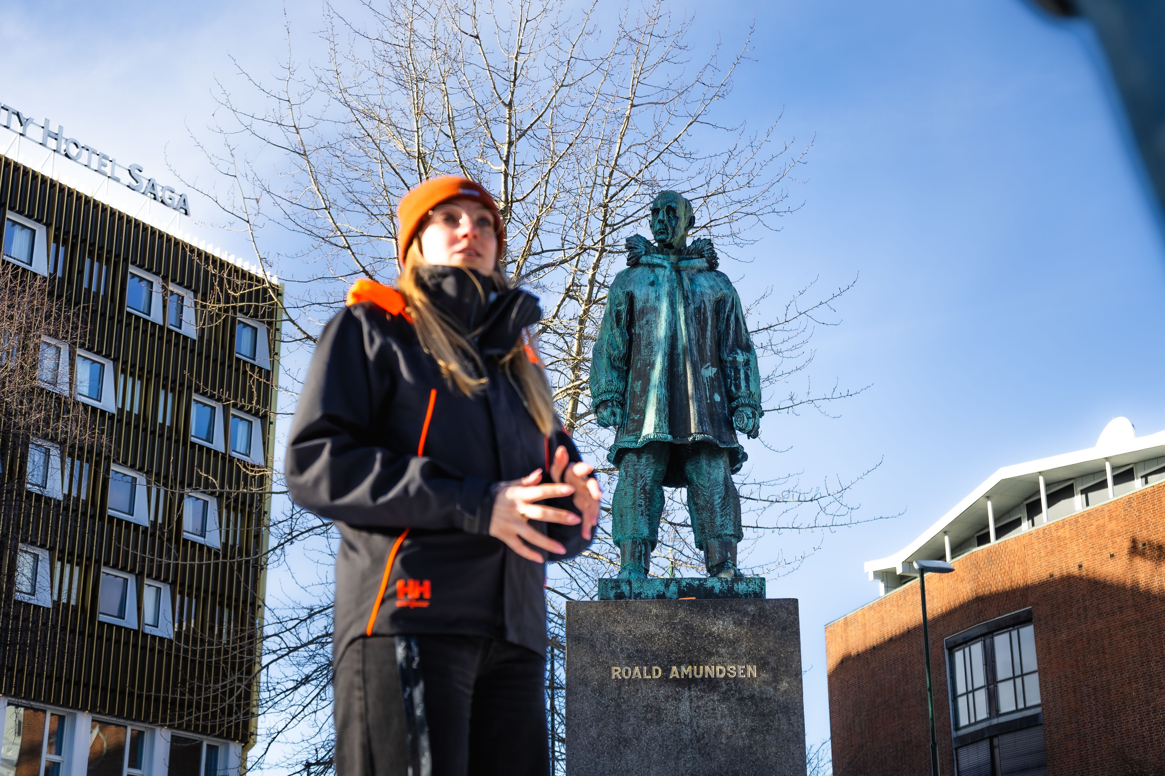 Guide presenting the Roald Amundsen statue during a walking tour in Tromsø, highlighting the city's rich polar exploration heritage.
