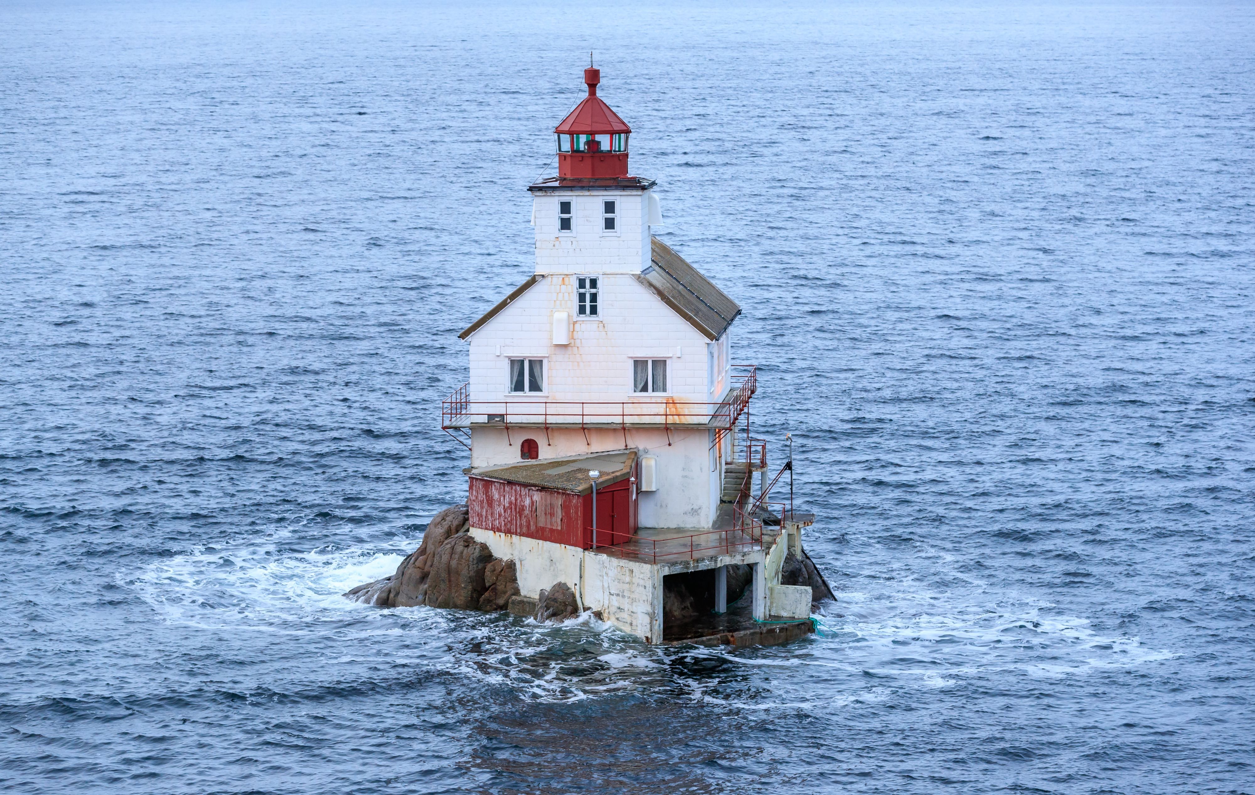 Stabben Lighthouse standing on a small rocky islet near Florø, Norway, surrounded by the calm waters of the North Sea