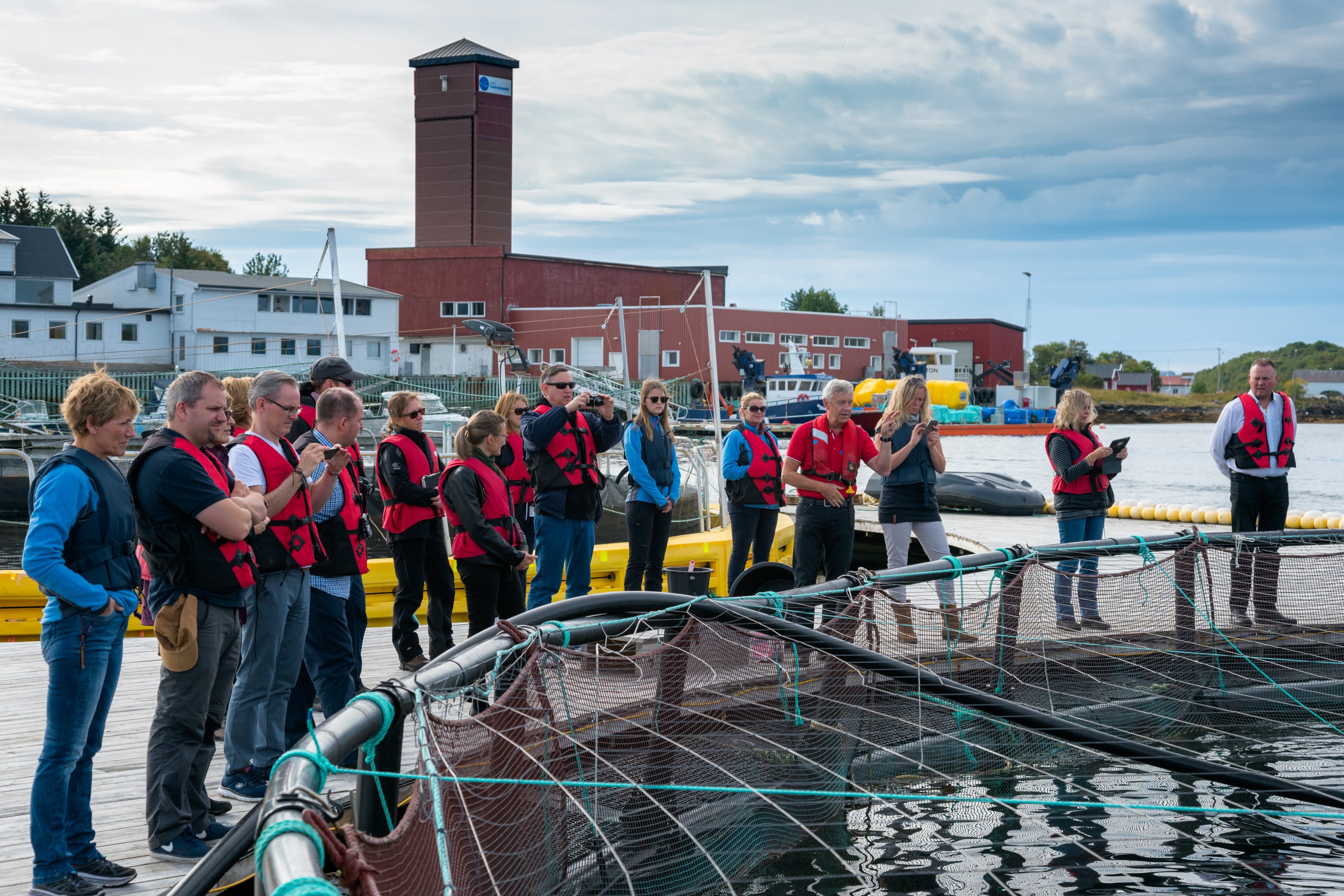 Excursion guests watching the salmon farm facilities