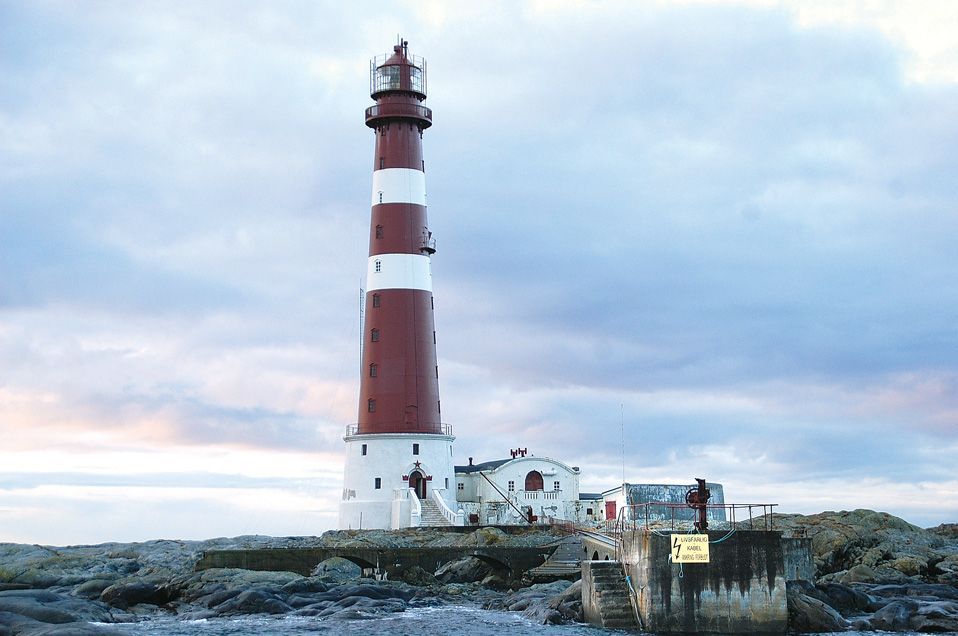Sletringen Lighthouse on a remote rocky island off the Trøndelag coast, standing above the Norwegian Sea under expansive skies