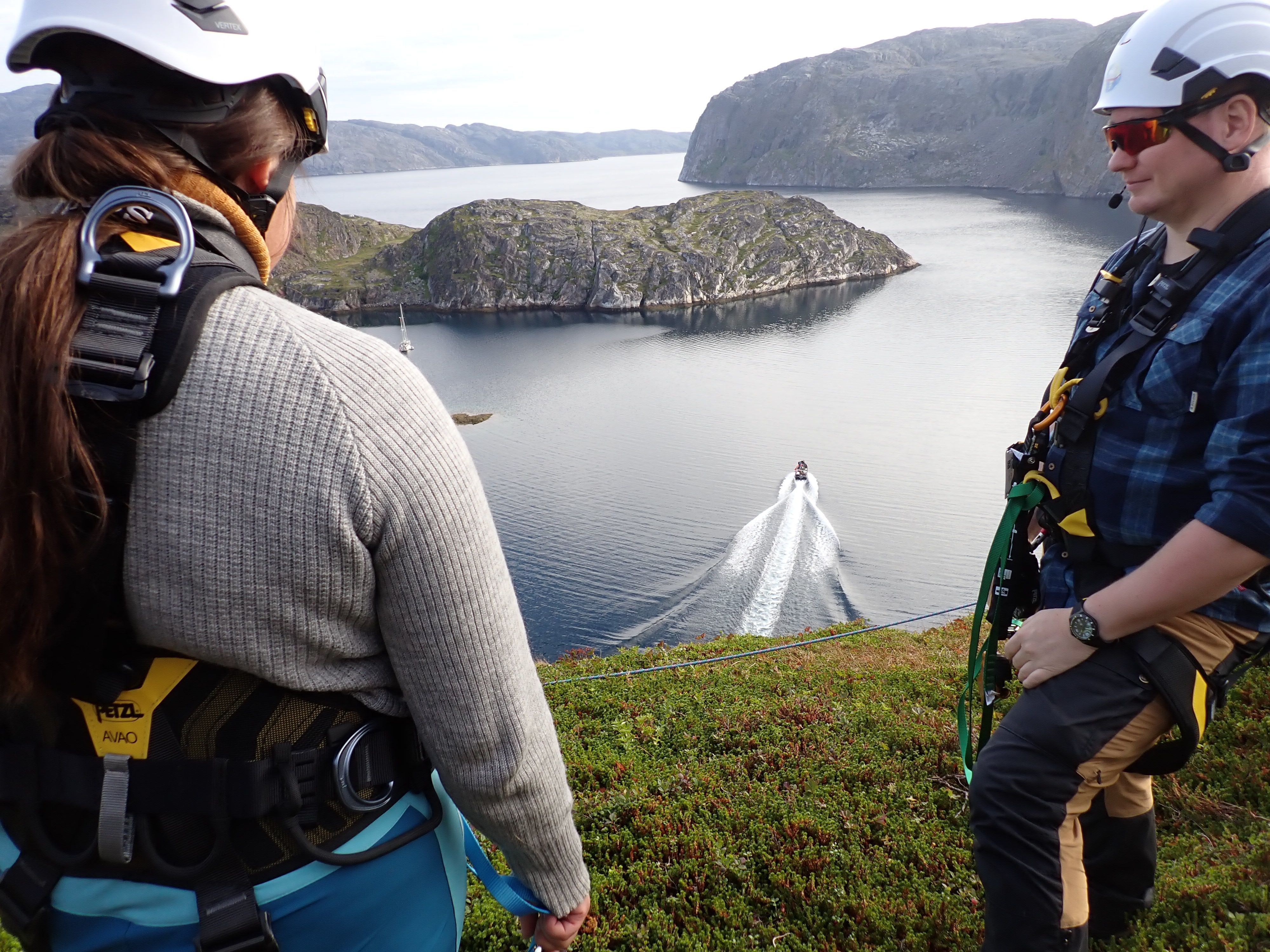 Participants in climbing harnesses overlooking a fjord before the Arctic Rappelling Route adventure in Northern Norway.
