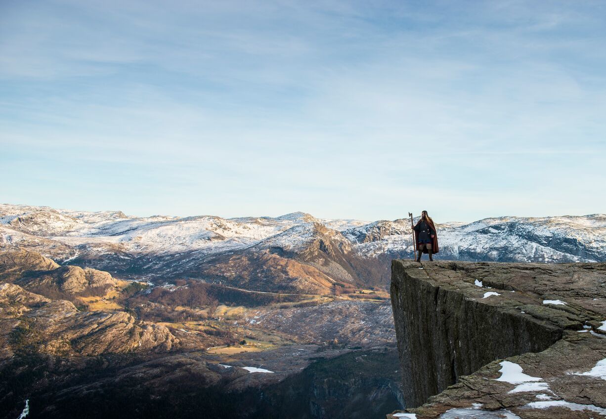 Ein Wikinger-Darsteller auf einer Klippe über der norwegischen Berglandschaft