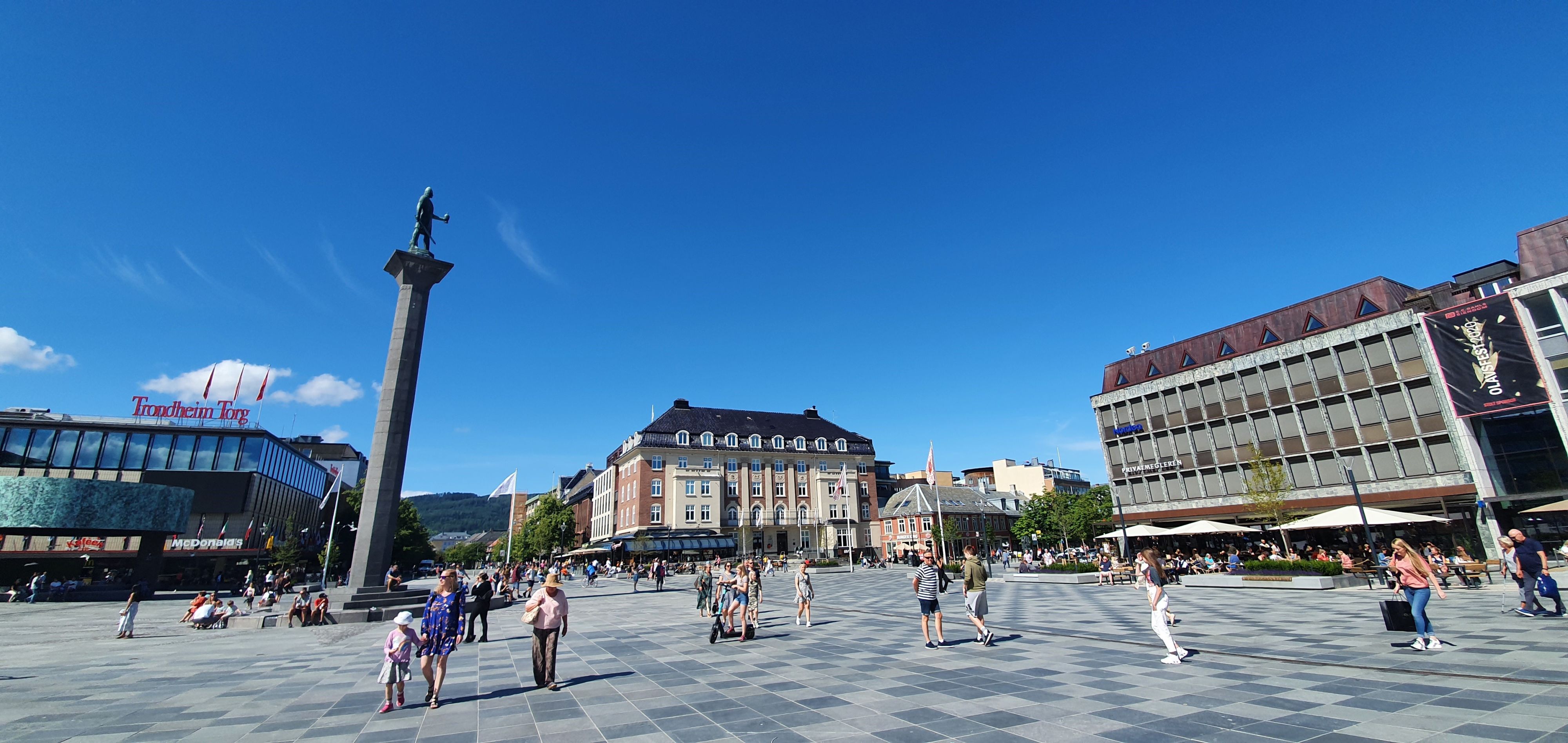 Folk på Torvet torg med Olav Tryggvason-monumentet på en solrik sommerdag i Trondheim, Norge