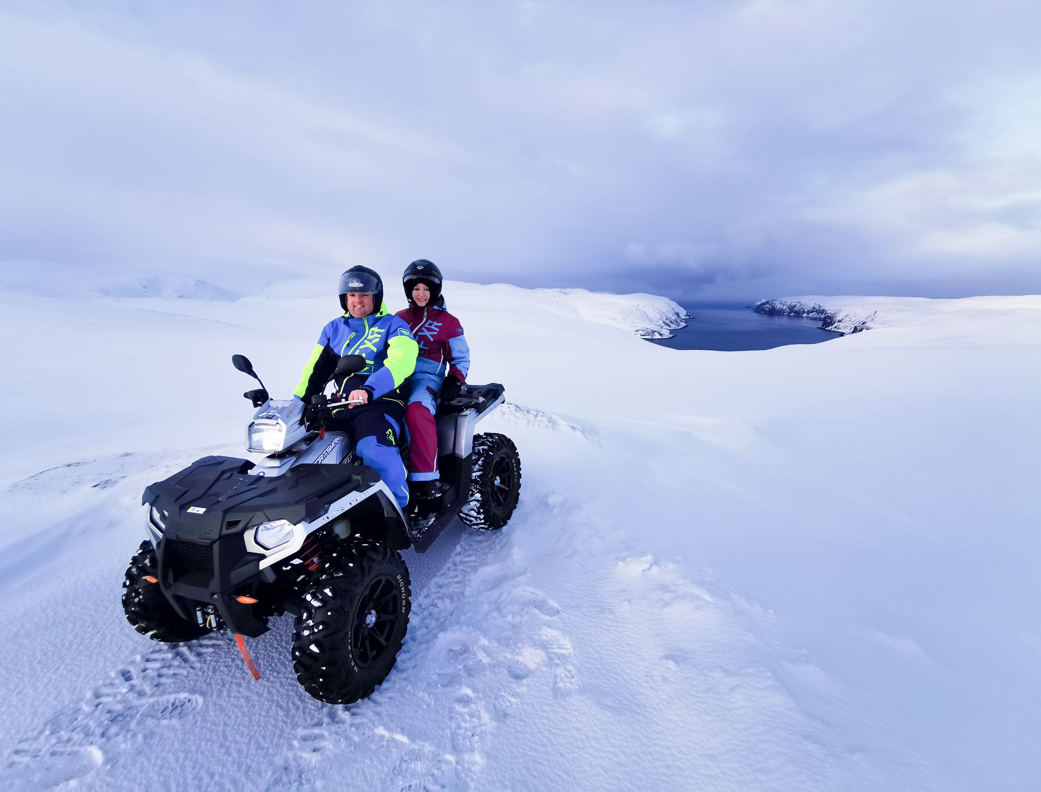Couple enjoying an ATV Winter Safari across snowy Magerøya.