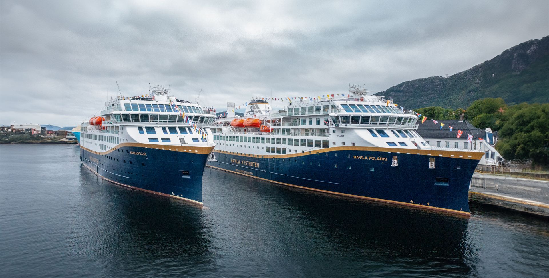 Havila Capella und Havila Polaris liegen Seite an Seite in Torvik, Norwegen, und präsentieren die modernen Küstenschiffe von Havila Voyages auf der norwegischen Küstenroute.