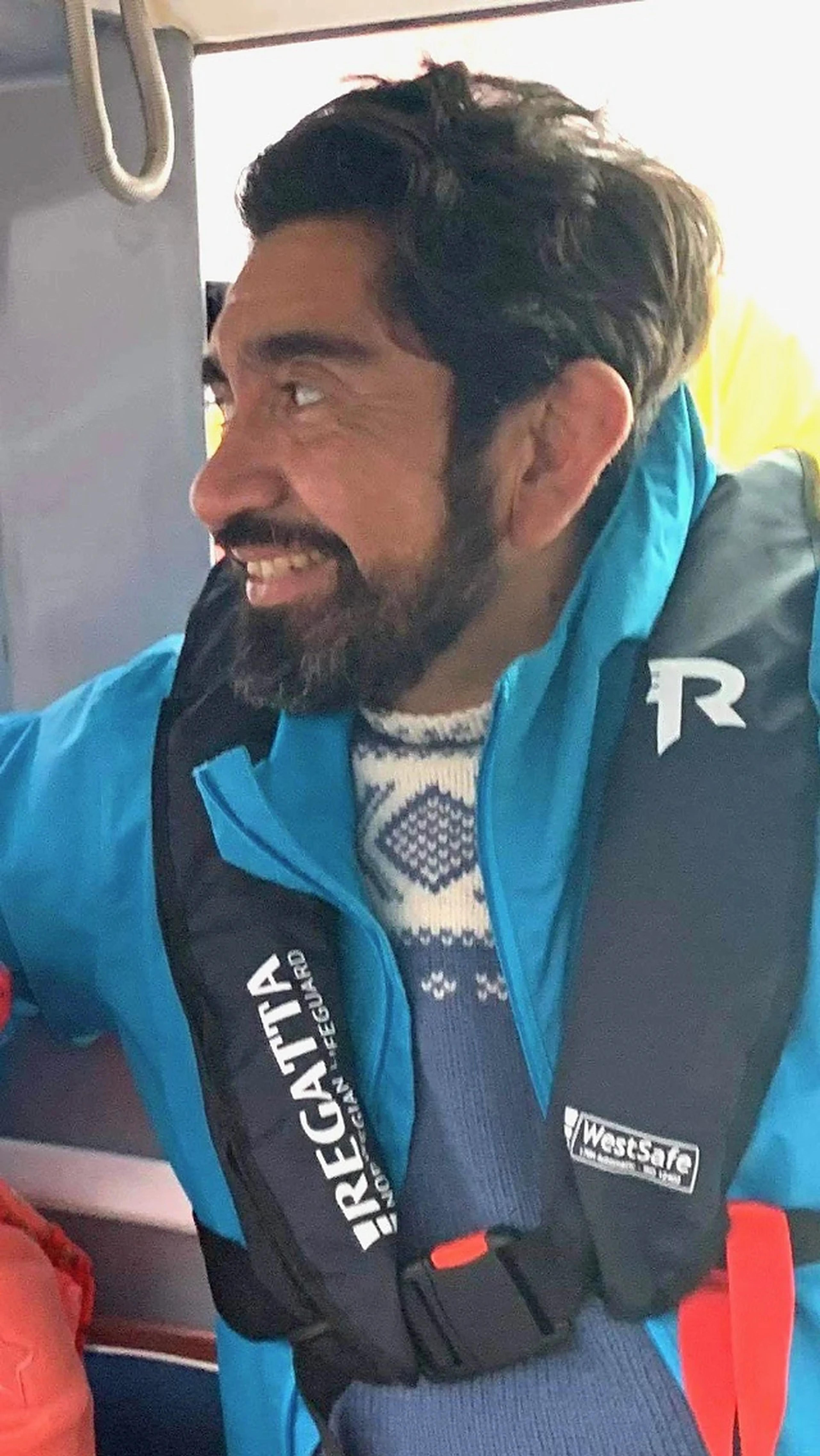Cristian sonríe con chaleco salvavidas a bordo de un barco