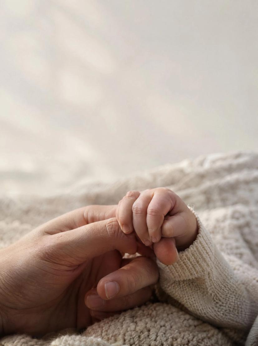 La mano de un bebé que agarra el dedo de un adulto