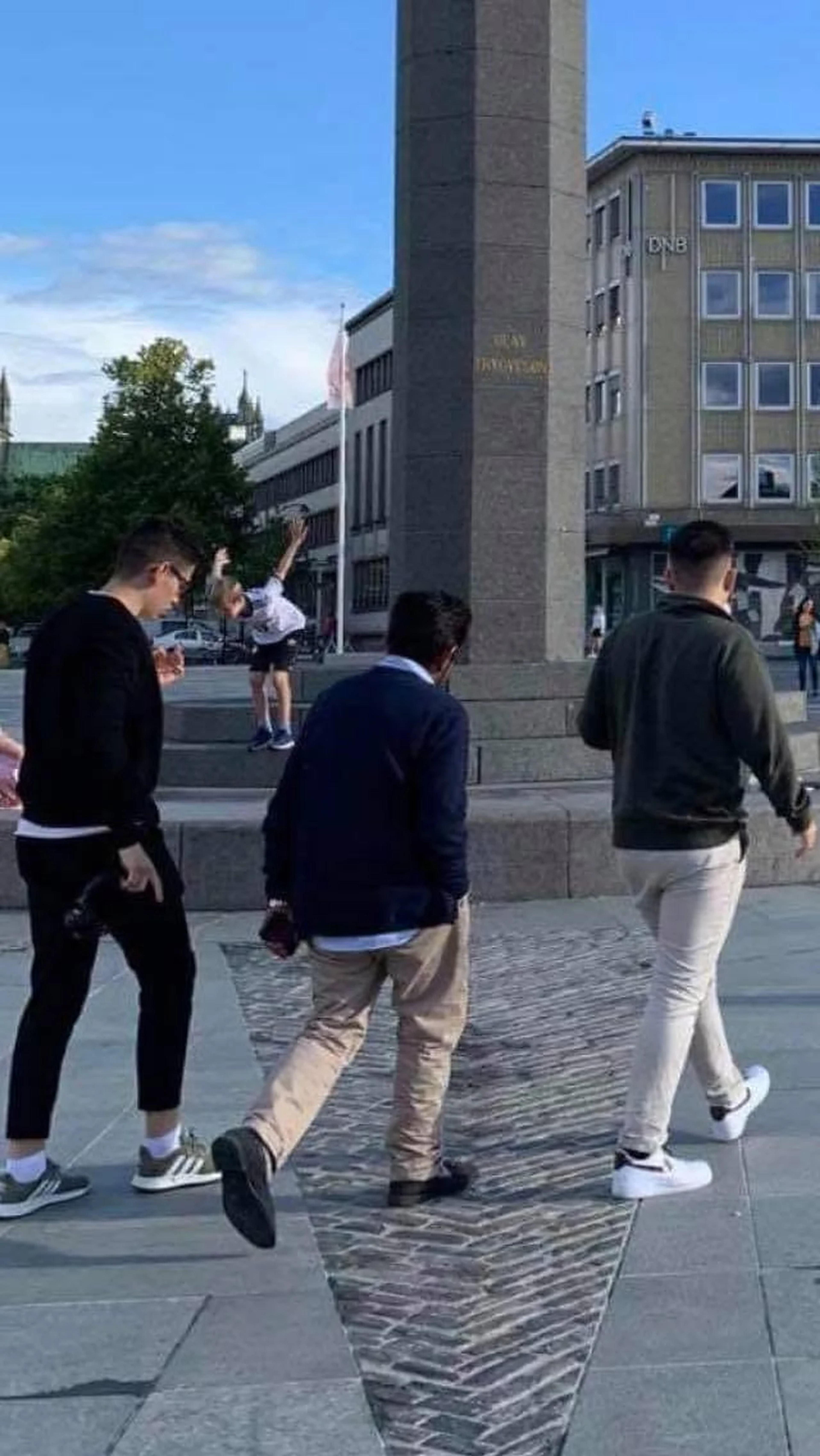 Cristian y sus hijos Marcus y Andreas cruzan la plaza de Trondheim, vistos de espaldas