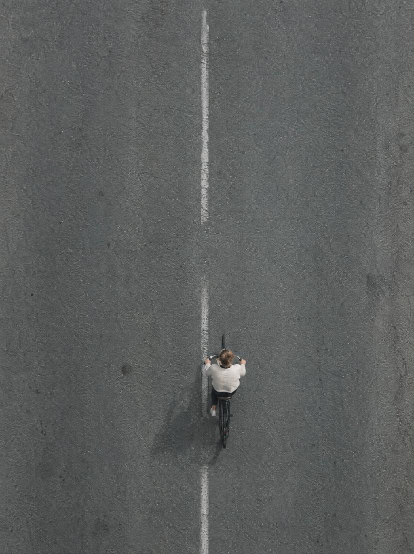 Un ciclista visto desde arriba en una carretera gris
