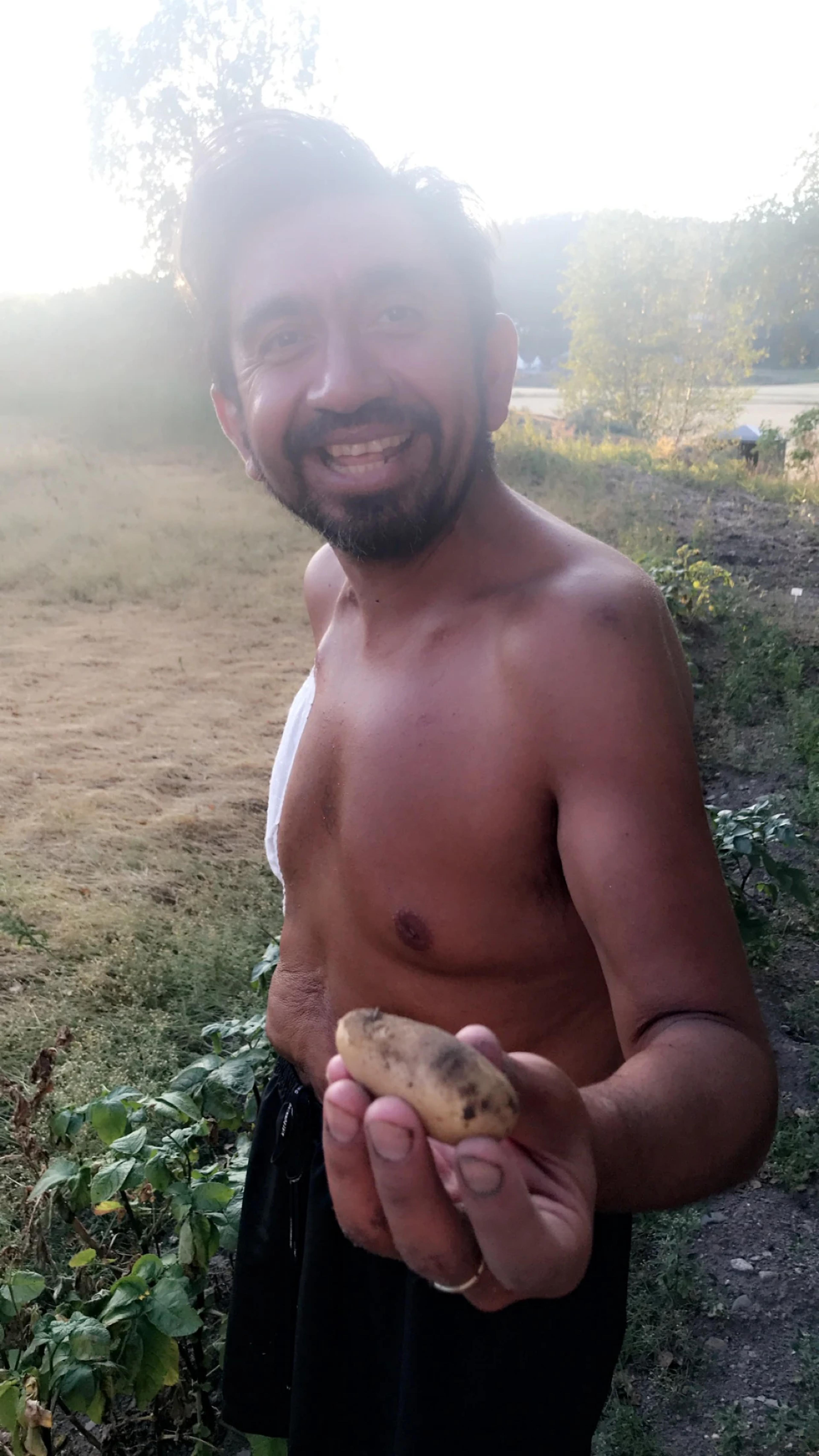Cristian muestra una patata que ha cultivado él mismo
