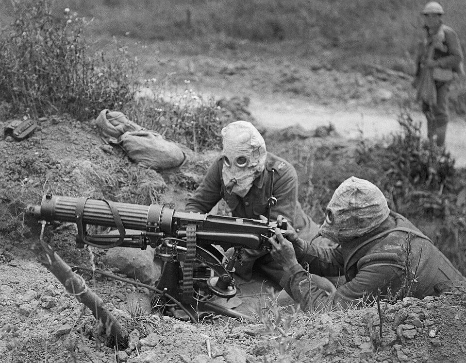 Vickers machine gun crew in firing position — gunner, loader, and spotter working as a single unit to range an assigned sector of fire