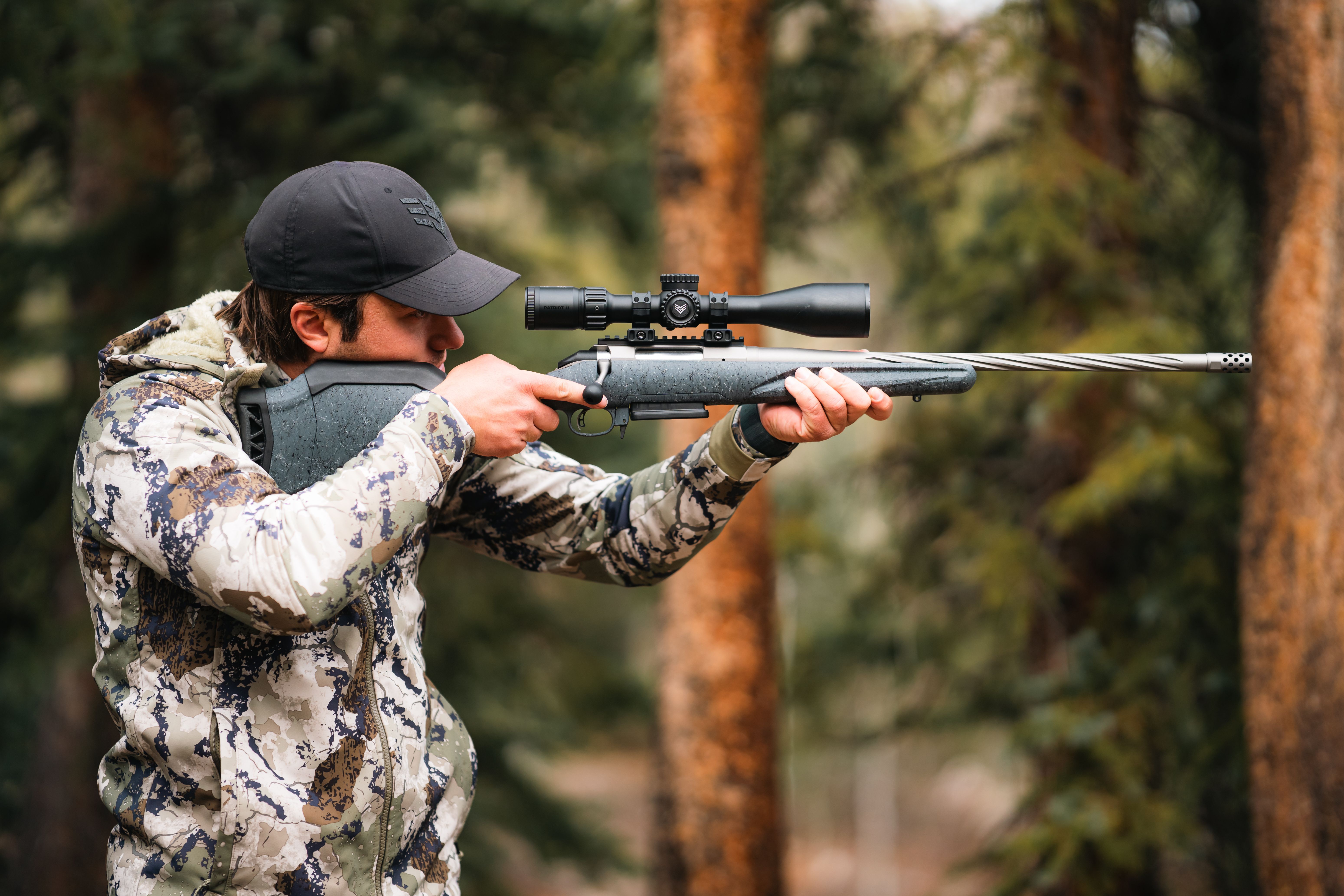 Hunter in the field holding a rifle with the Patriot II mounted
