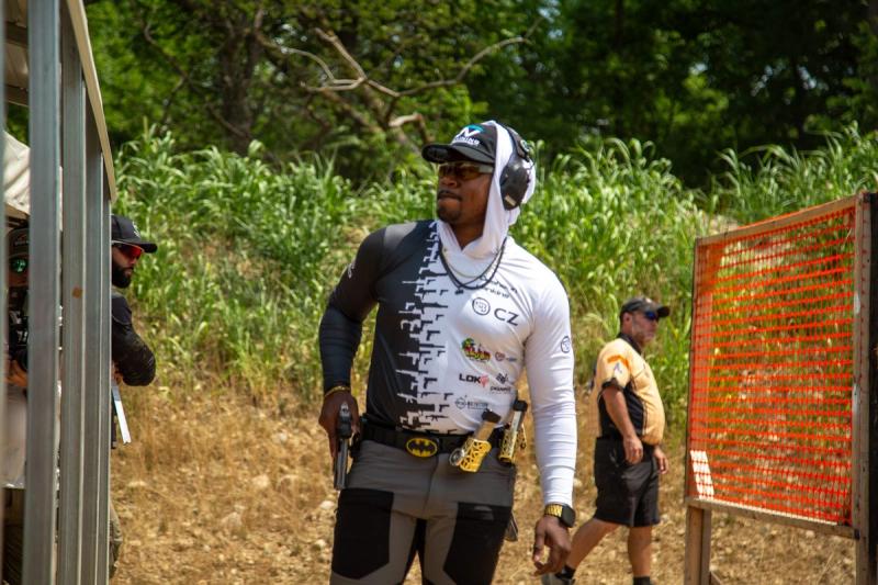 Desahun 'DJ' Jenkins competing in a USPSA match, pistol drawn from his holster