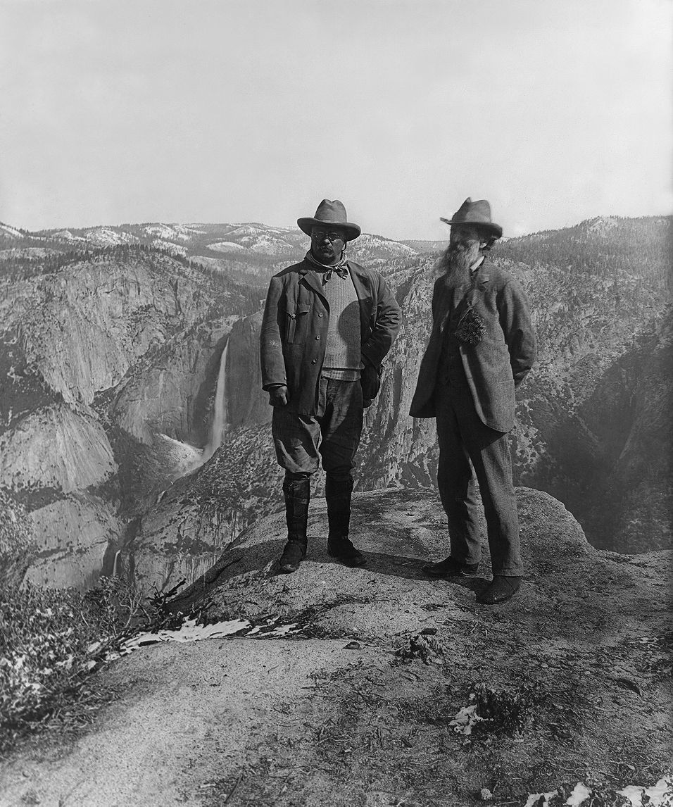 John Muir and Theodore Roosevelt standing on a scenic overlook in the wilderness