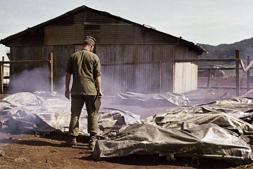 U.S. soldier standing over fallen soldiers on the Vietnam battlefield