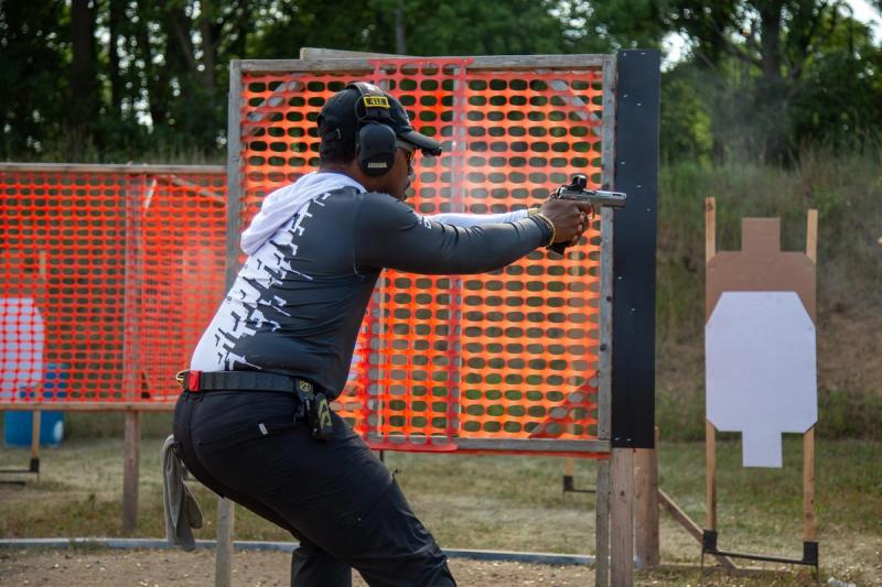 DJ Jenkins leaning around a barricade, engaging a steel target