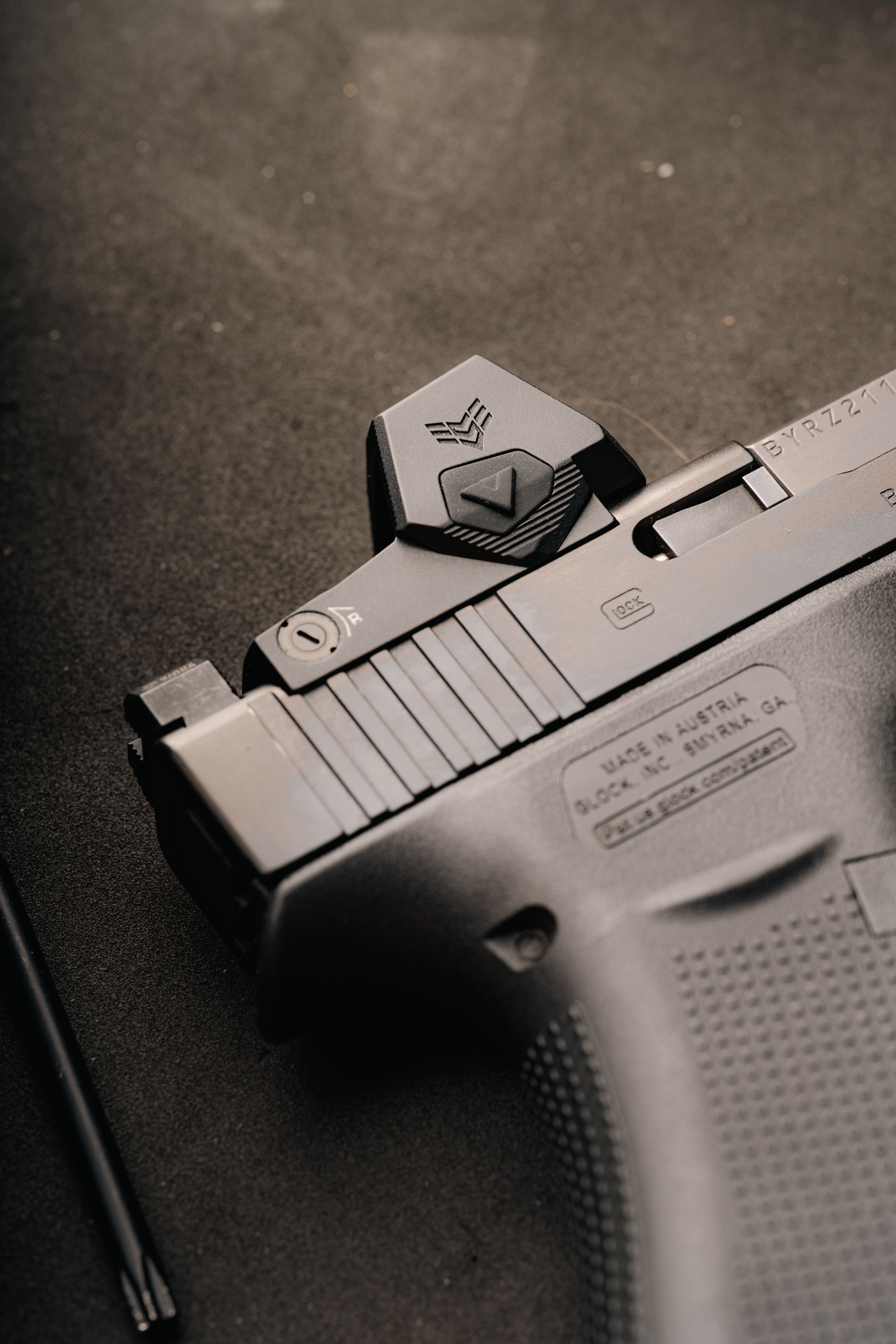 Close-up of a slide-mounted red dot optic on a competition pistol
