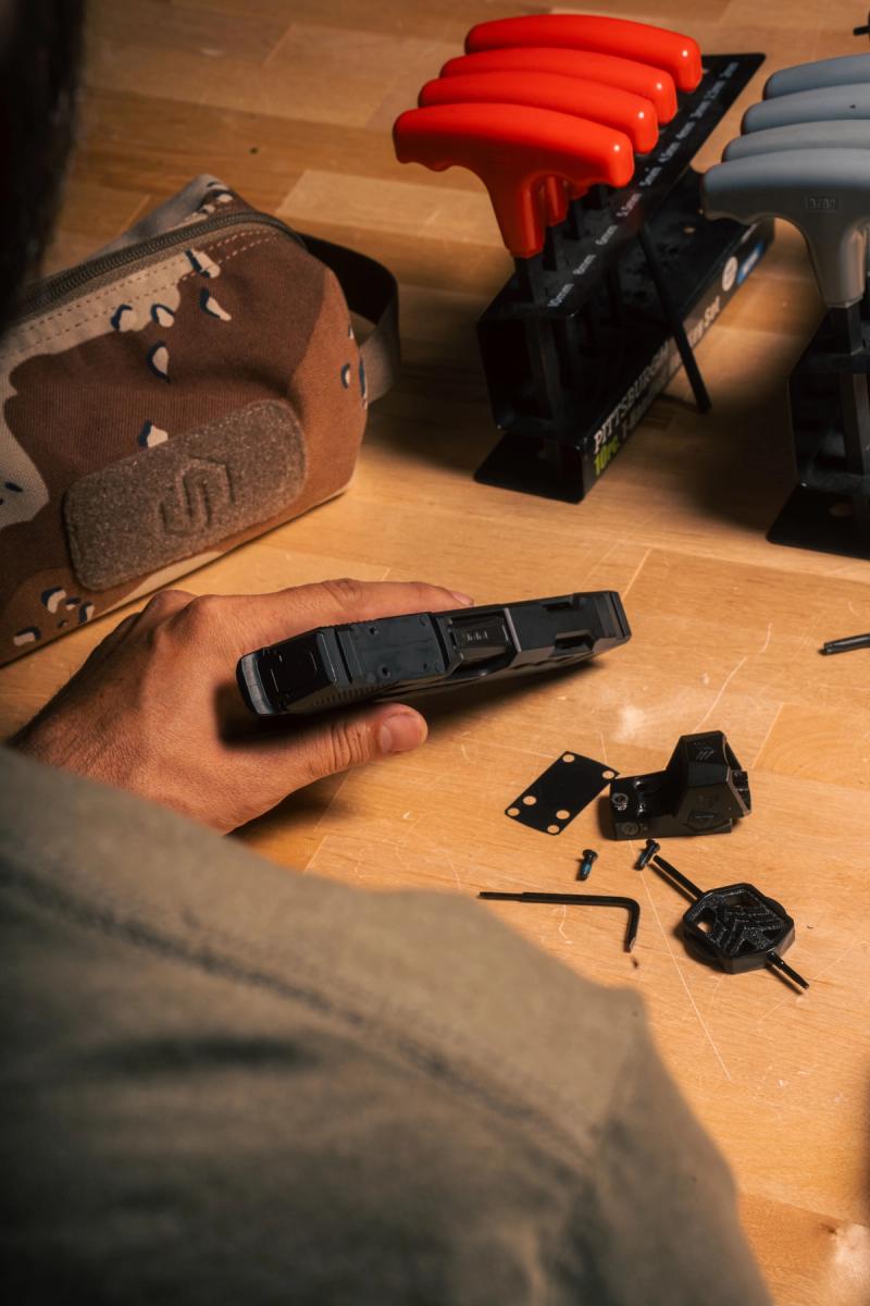 Swampfox Sentinel II and Sig P365 parts laid out on a workbench during mounting