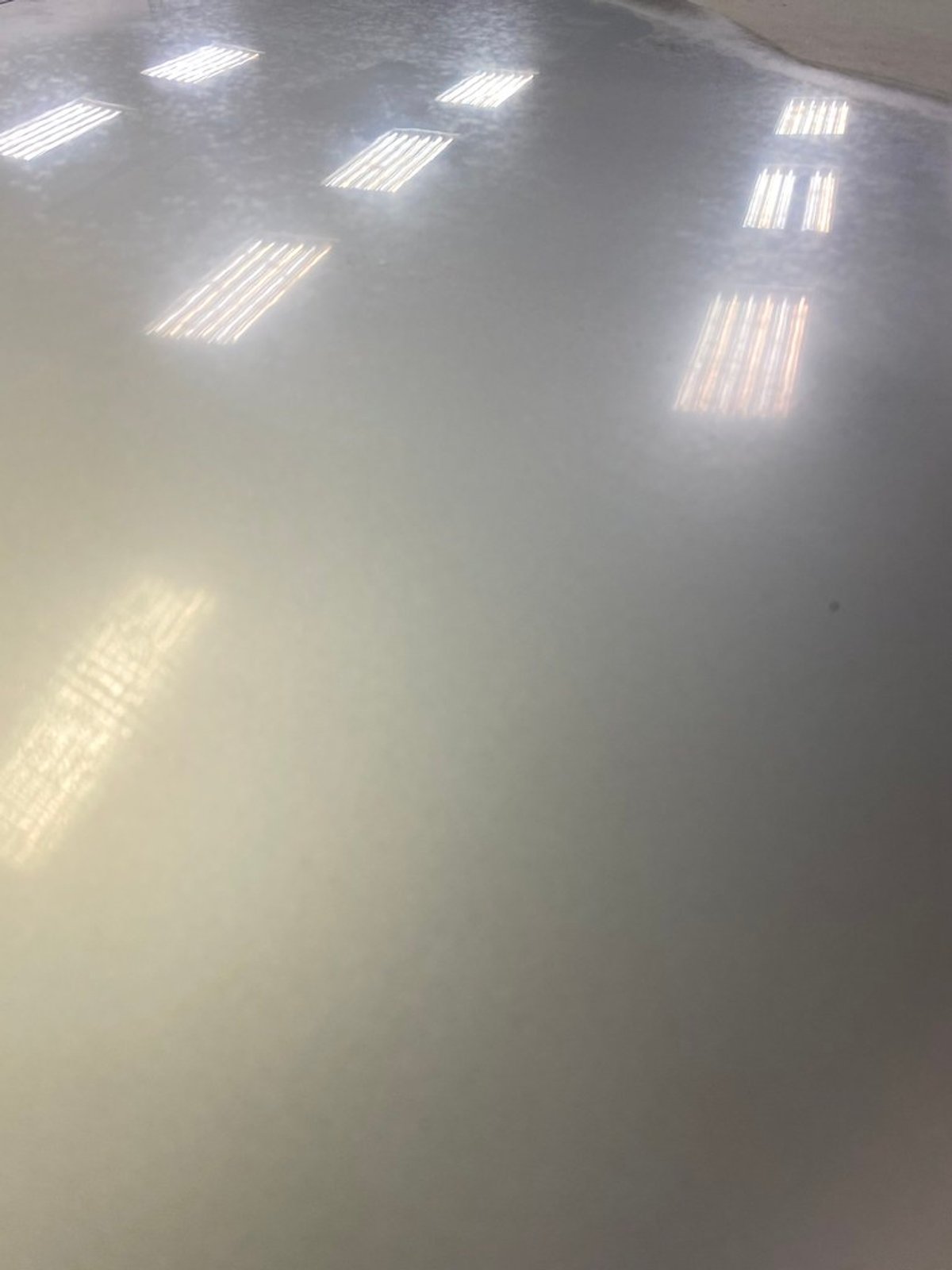 Silver BMW M3 hood under shop lights, half hazy and uncorrected, half polished to a clear reflection
