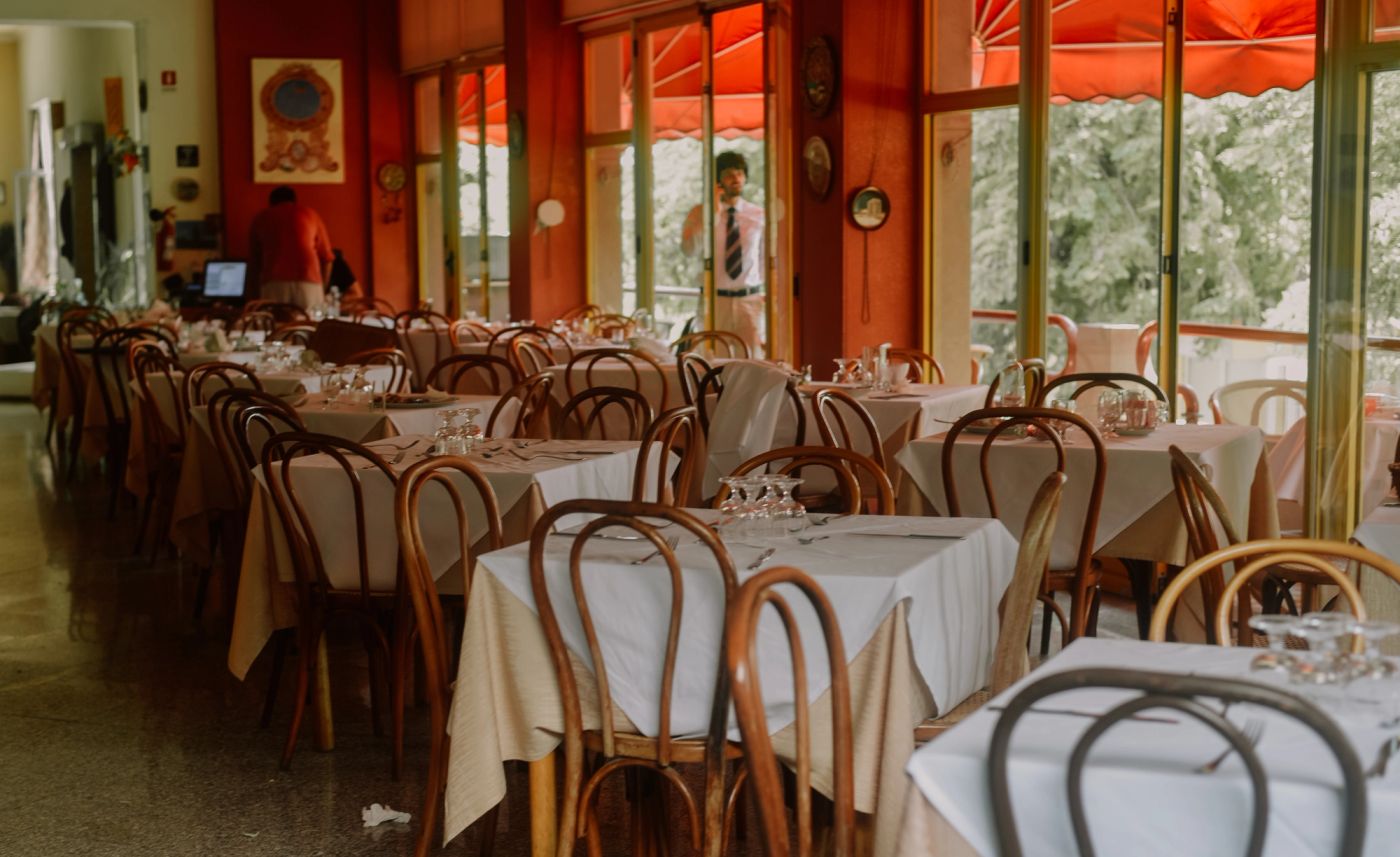 Restaurant dining room with set tables and red umbrellas
