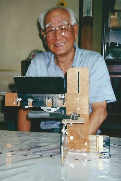 Iwasaki at home explaining his magnifying glass stand to Paula Arai on August 8, 2000 (Photo: Paula Arai)