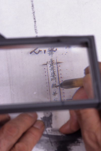 Iwasaki using his homemade template and magnifying glass stand to paint (Photo: Kenichi Arakawa)