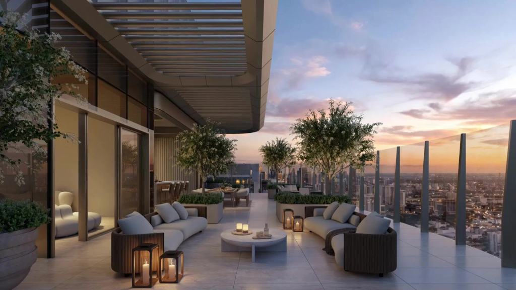 Rooftop lounge terrace with sofas, lanterns and olive trees at sunset over the city.
