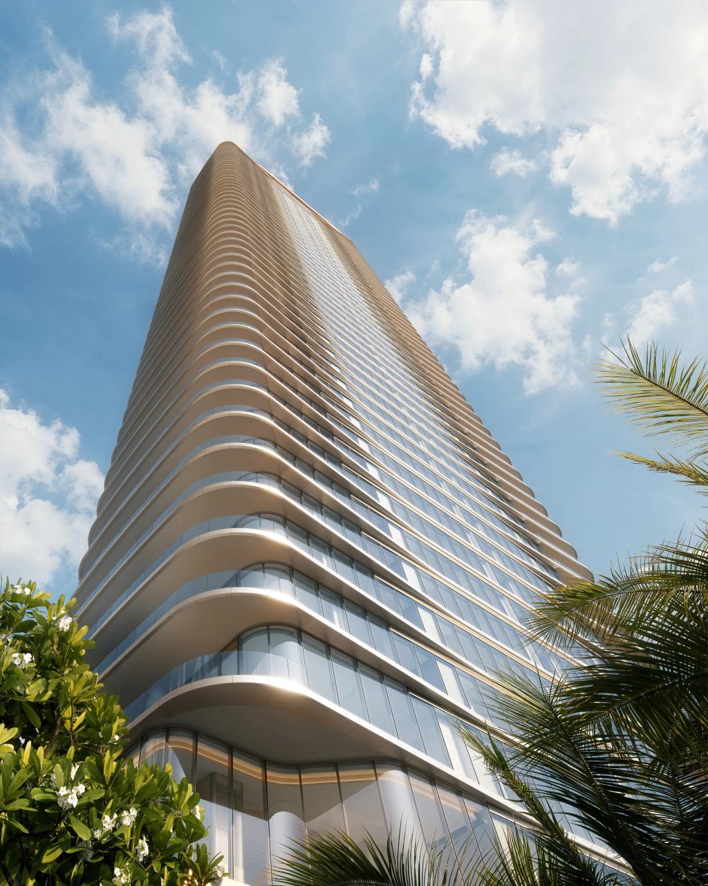 Looking up at LILLI’s curved, fluted tower against a blue sky, framed by palms and flowering frangipani.