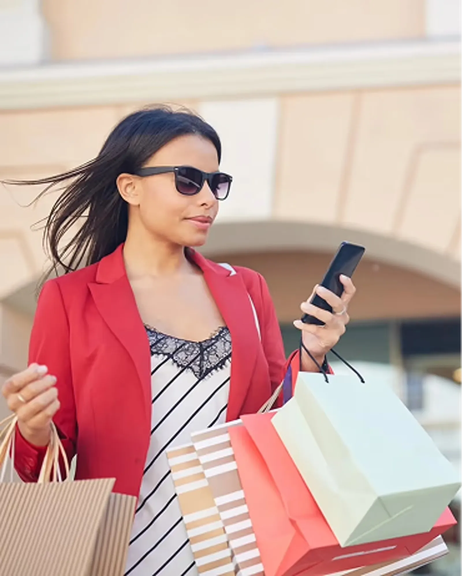 A woman shopping and holding her phone.