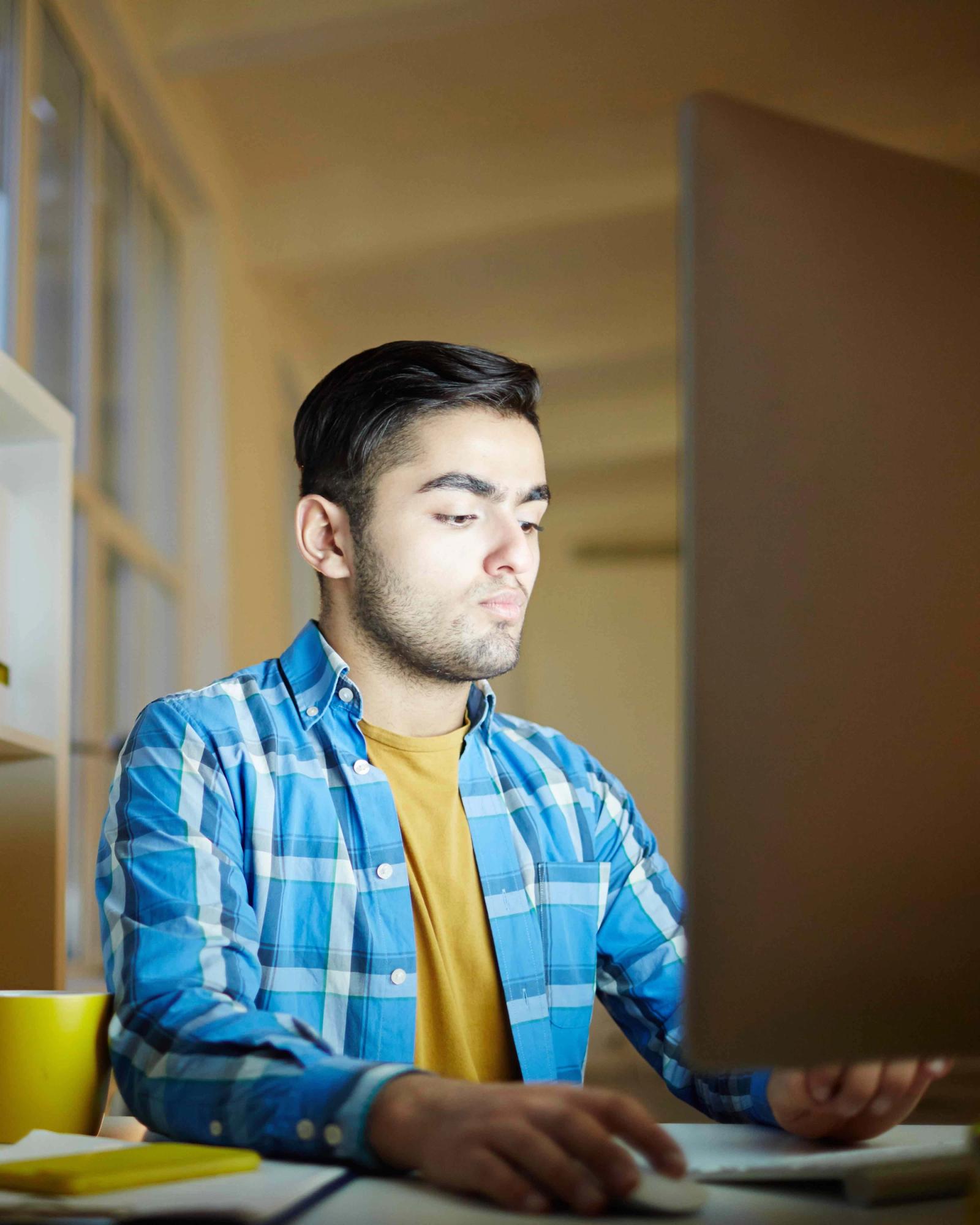 A man typing something on his computer.