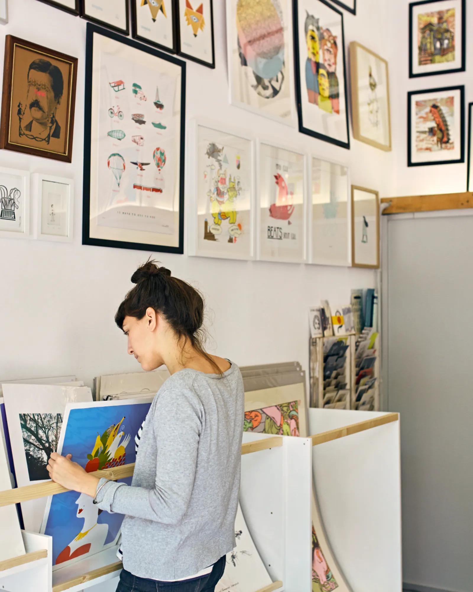 Woman sorting through paintings in a studio