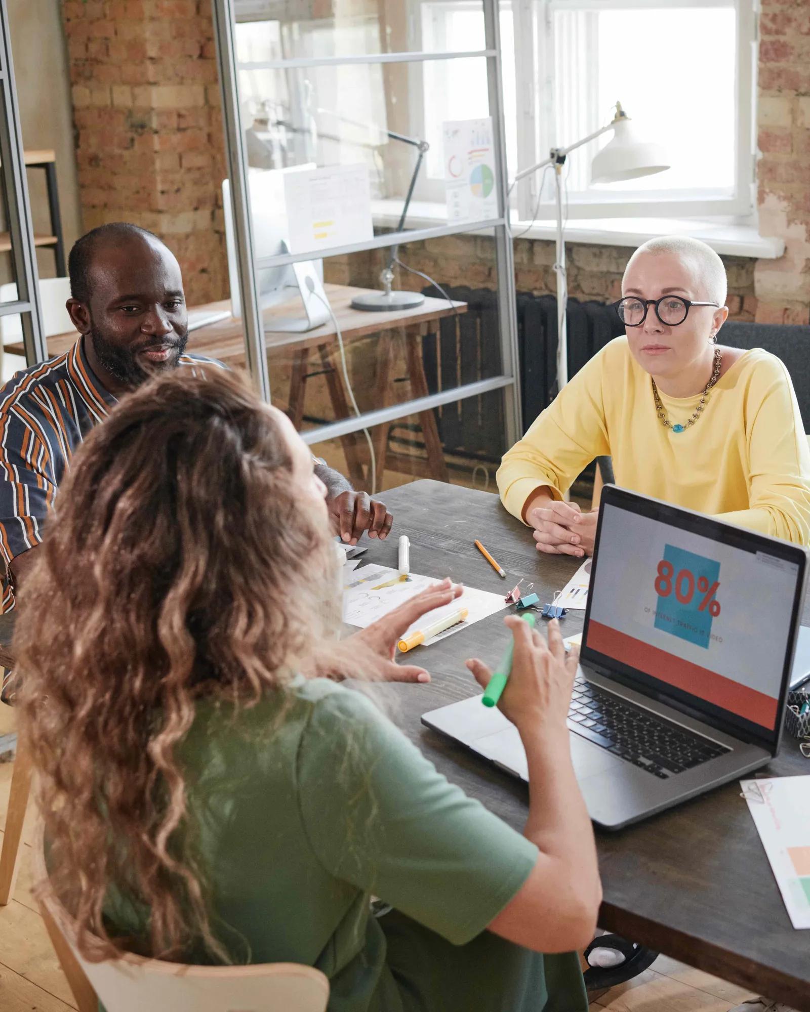 A team of marketers discussing impact and costs associated with paid marketing.