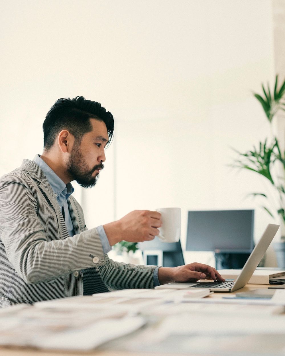 An example of a customer on their computer, drinking a coffee.