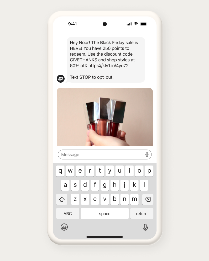 A smartphone screen showing a text message about a Black Friday sale with a photo of a hand holding four bottles of lip gloss.