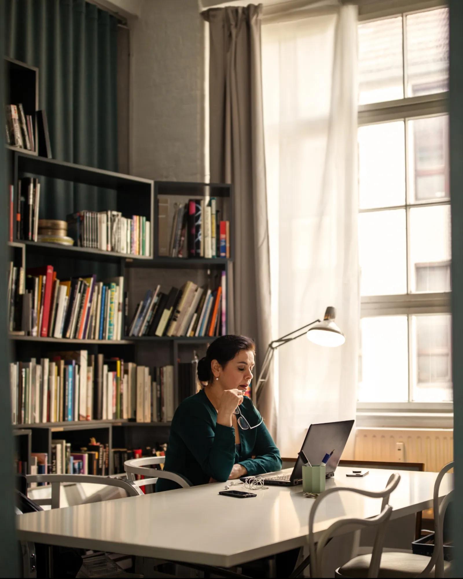 Woman working on a laptop in a library