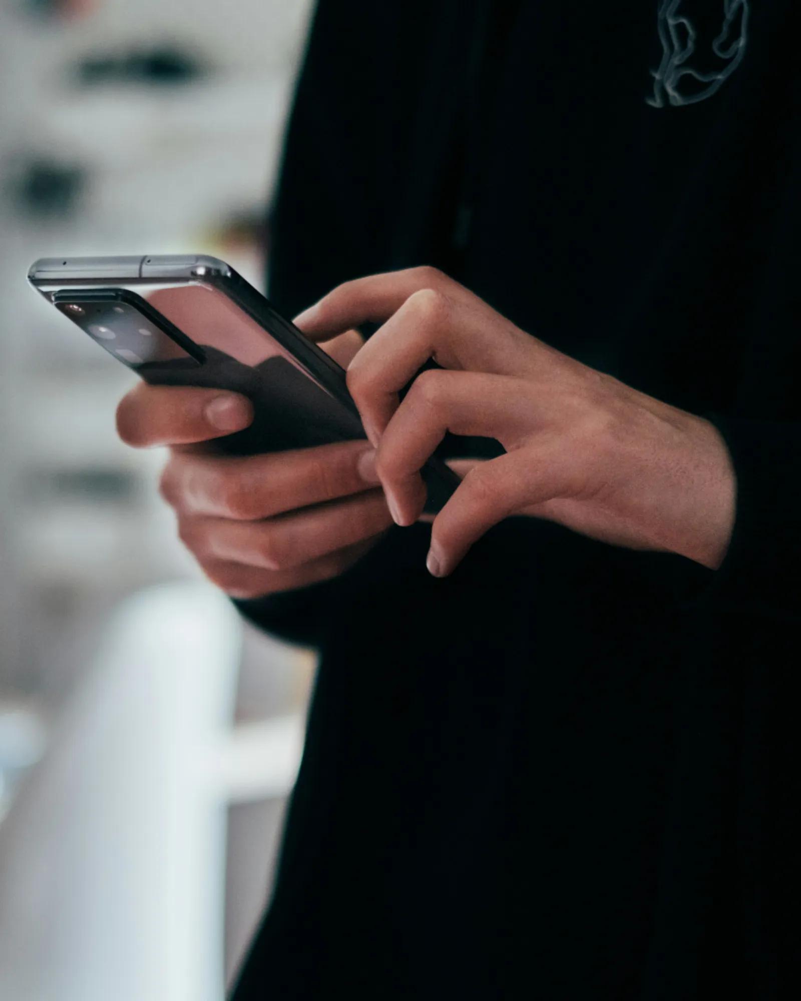 A close-up of a consumer browsing their phone