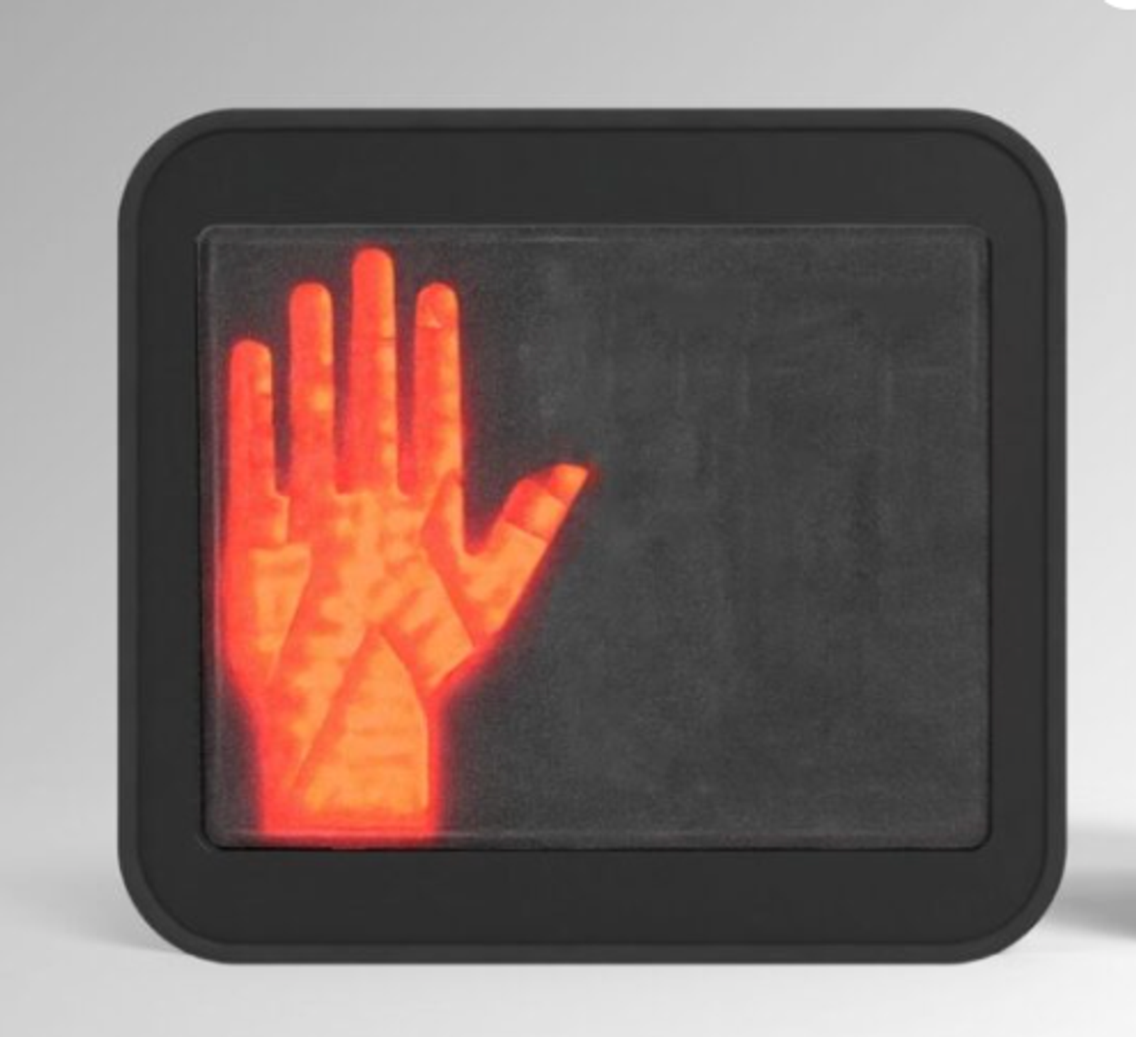Red illuminated hand symbol on a pedestrian stop signal.