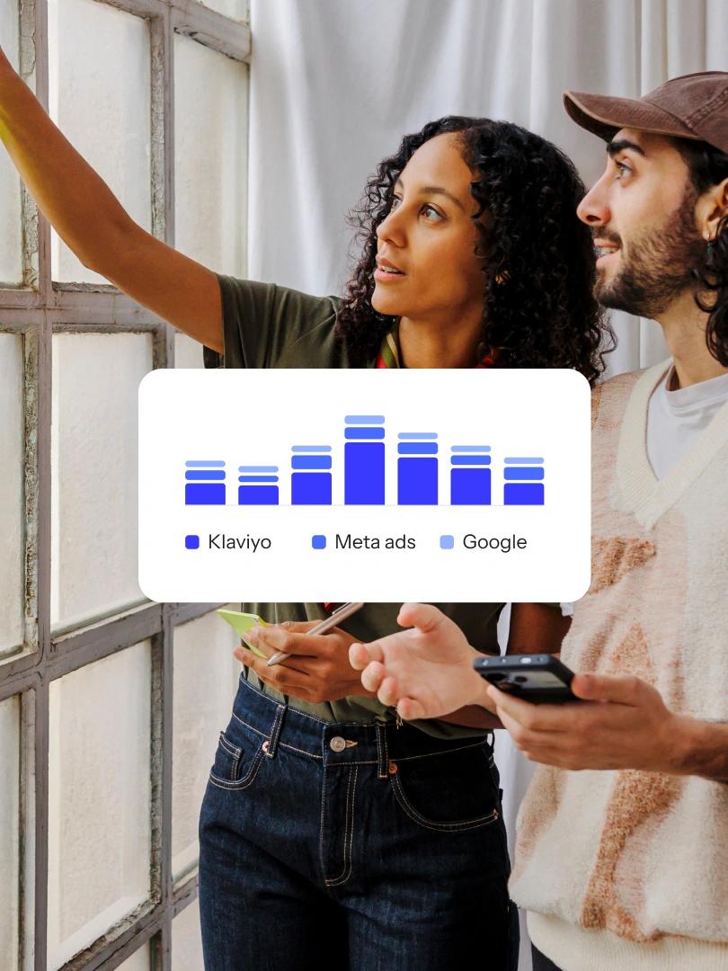 Two marketers collaborate beside a chart comparing Klaviyo, Meta ads, and Google.