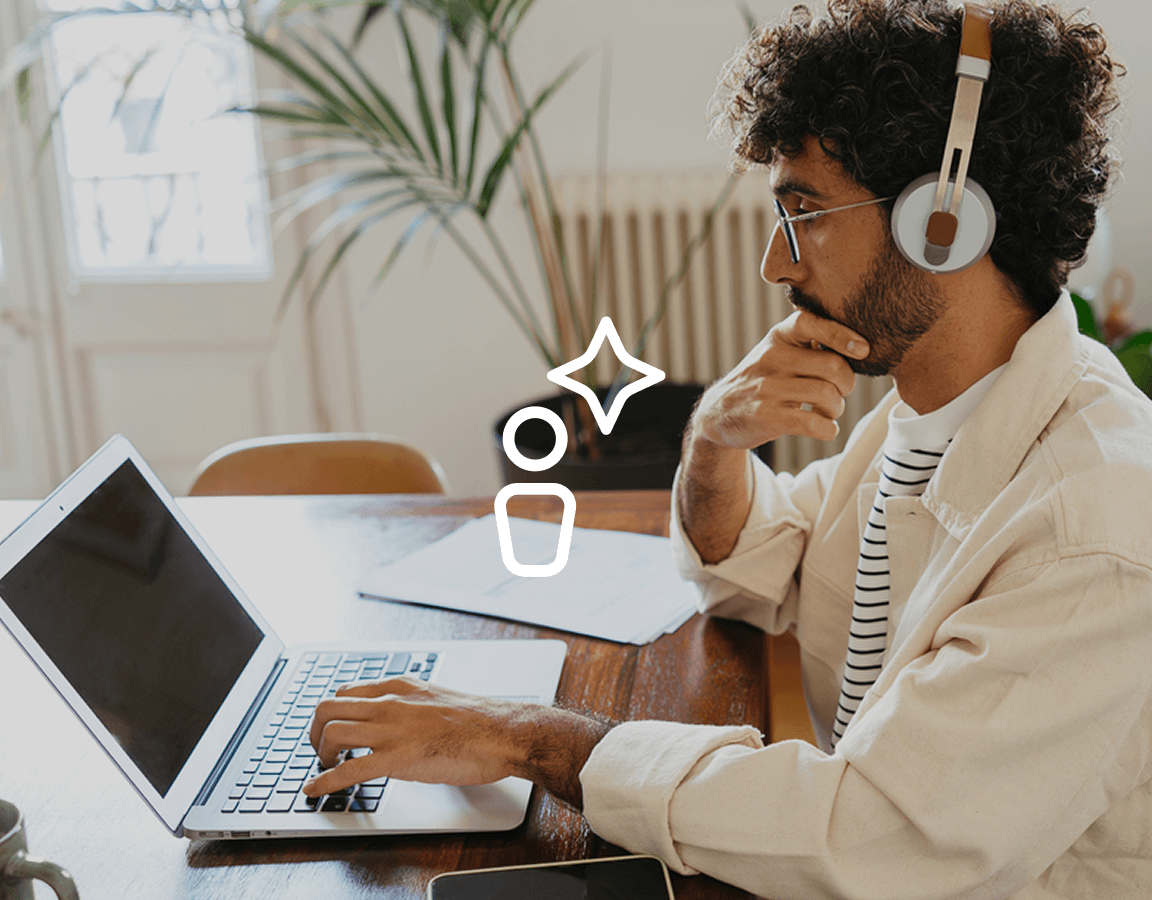 A photograph of a man working on a laptop.