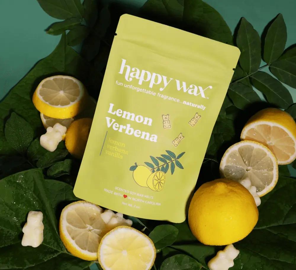 Happy Wax Lemon Verbena wax melt pouch surrounded by lemons, green leaves, and bear-shaped wax melts.