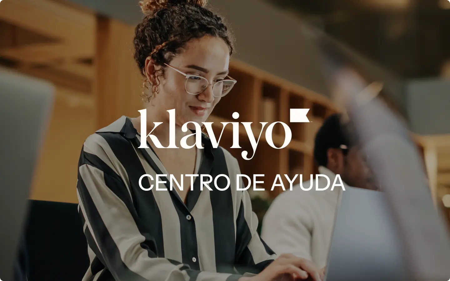 Mujer trabajando en una computadora portátil con el texto "Klaviyo Centro de Ayuda" superpuesto.