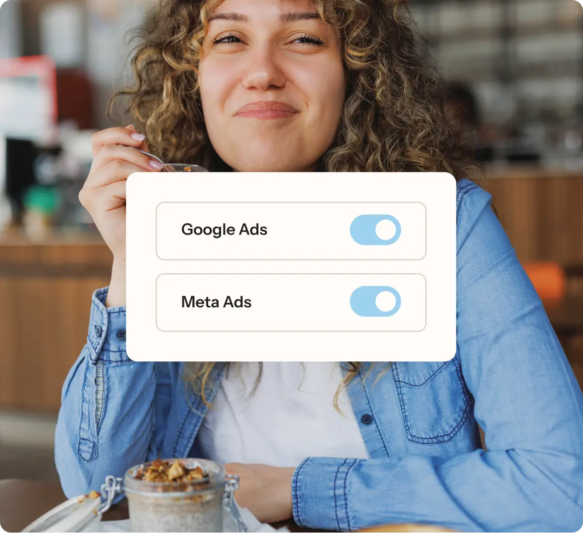 Woman in a restaurant eating, with overlay showing toggles for Google Ads and Meta Ads.