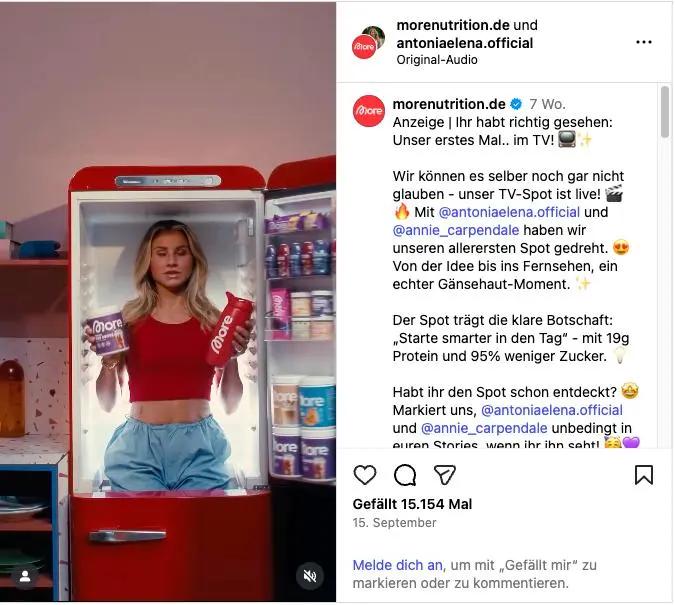 Frau in rotem Oberteil steht in einem offenen Kühlschrank und hält zwei "More Nutrition"-Produkte. Instagram-Post daneben.
