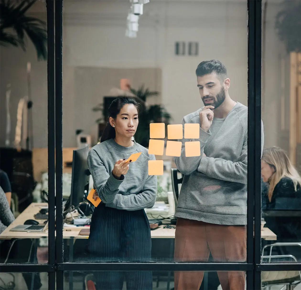 Ecommerce marketers look at a whiteboard to plan marketing campaigns and promotions.