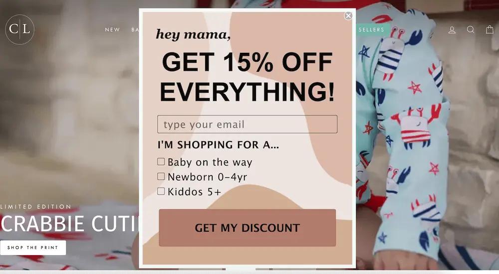 Image shows a pop-up form from Caden Lane, offering 15% off in exchange for the visitor’s email address and encouraging them to identify whether they’re shopping for a baby on the way, newborn 0–4 years old, or kids above the age of 5.