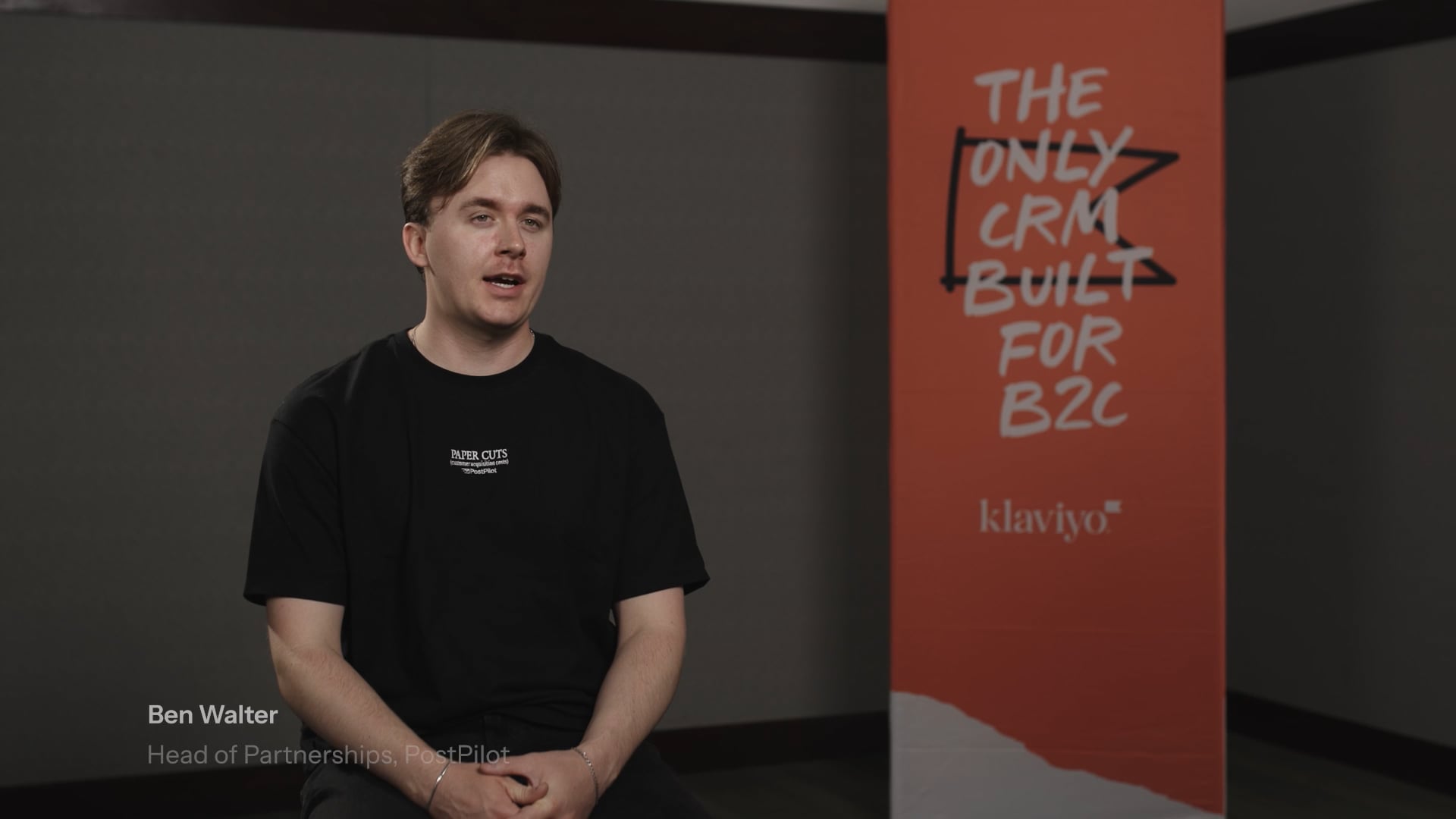Ben Walter, Head of Partnerships at PostPilot, speaks in front of a Klaviyo banner that reads "THE ONLY CRM BUILT FOR B2C."