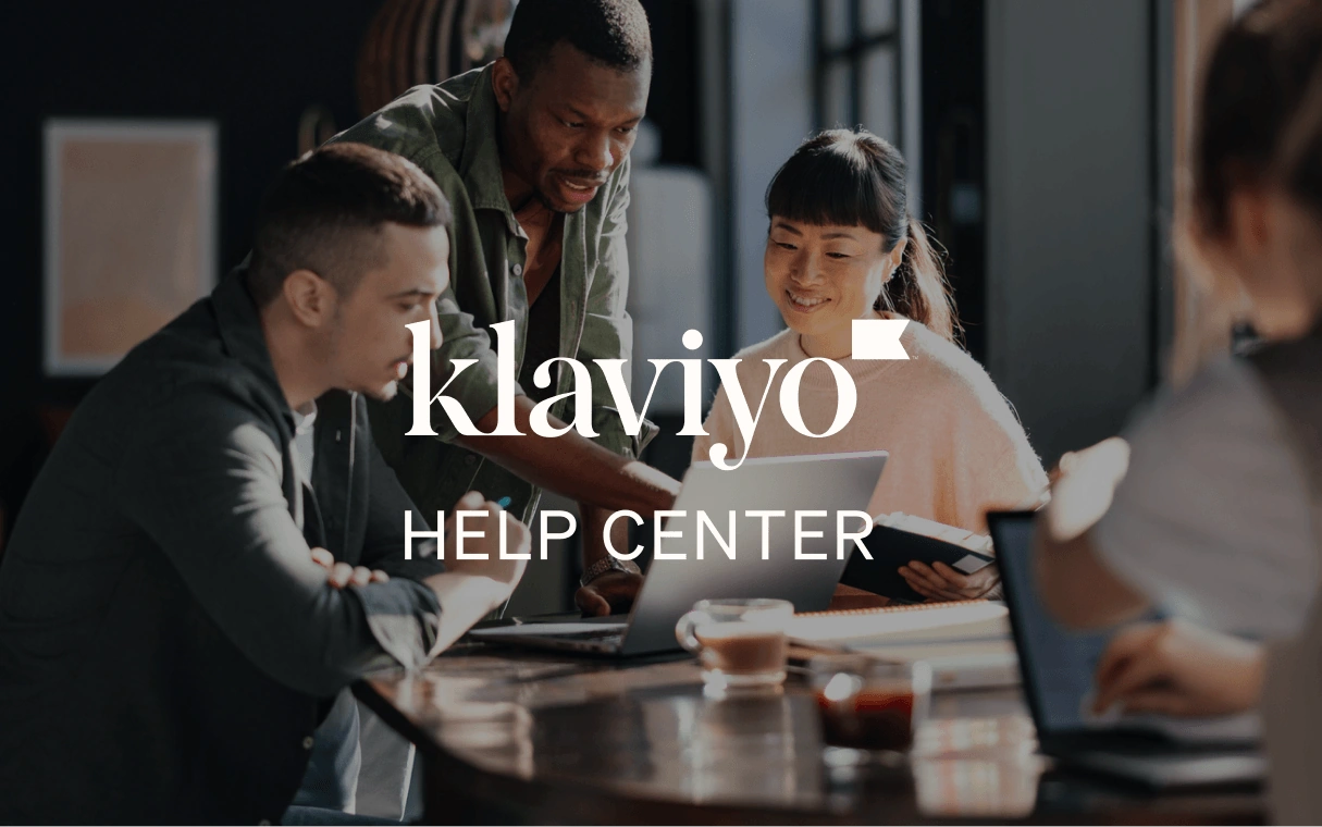 Coworkers collaborate around laptops at a table, overlaid with the Klaviyo Help Center logo.