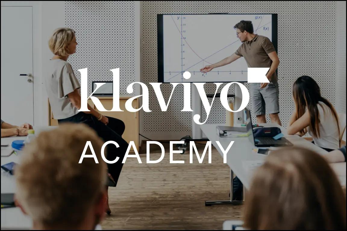 Le persone assistono a una lezione con un grafico su uno schermo. Testo sovrapposto: "Klaviyo Academy".