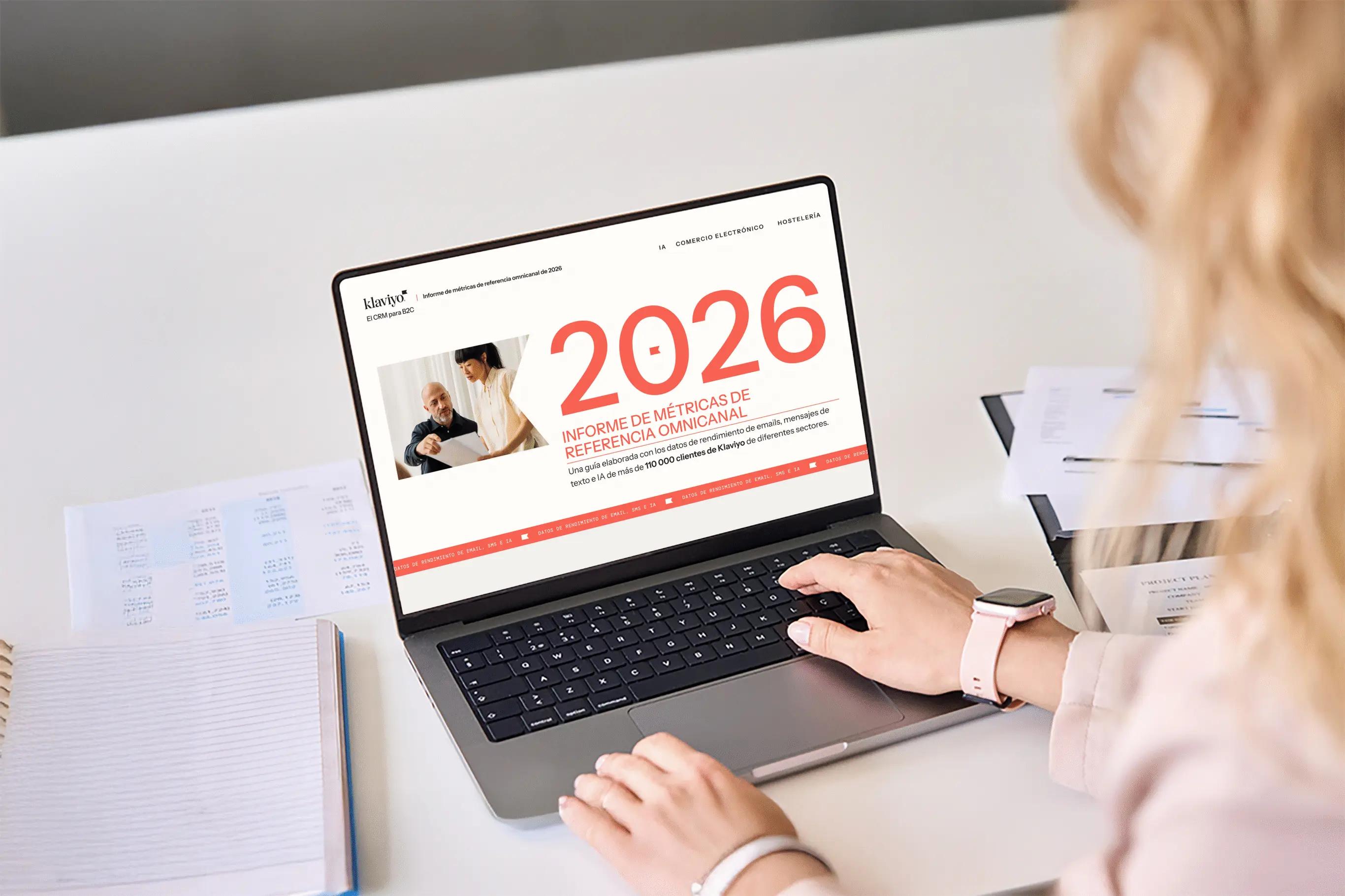 Persona usando una laptop que muestra un informe titulado "2026 Informe de Métricas de Referencia Omnicanal" de Klaviyo.