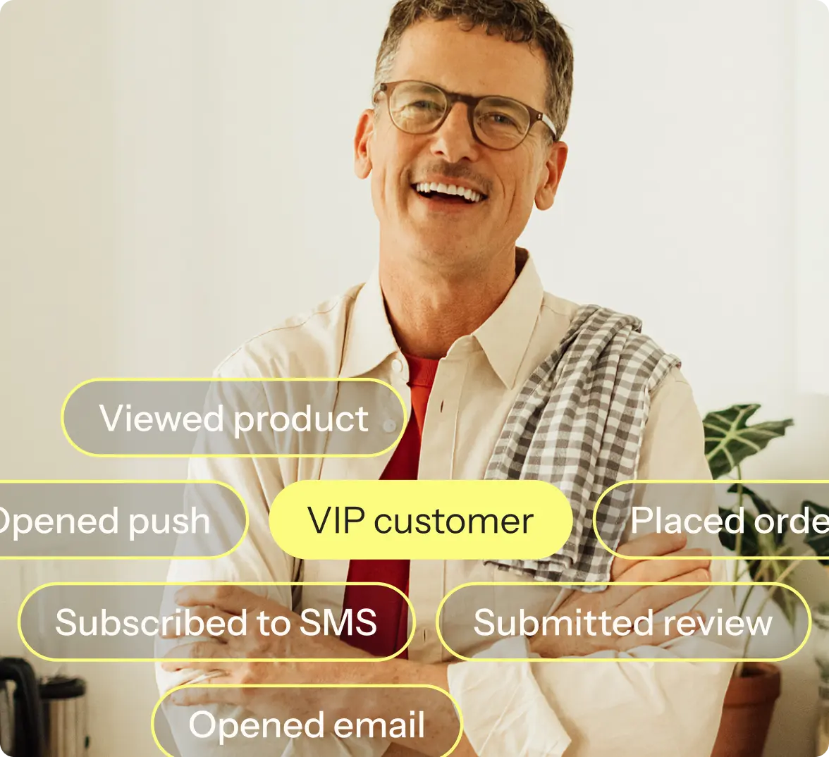 Smiling man with glasses and a checkered towel over his shoulder, surrounded by text bubbles: "Viewed product," "VIP customer," "Placed order," "Opened push," "Subscribed to SMS," "Submitted review," "Opened email.